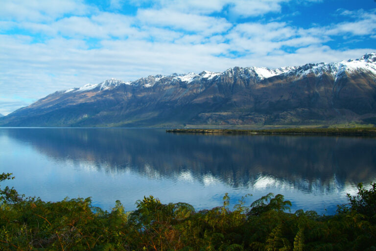 Mountain and lake scene. Blue clouded sky